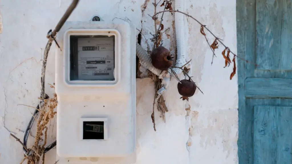 Elektros skaitiklis ant senovinės sienos, simbolizuojantis elektros tarifų peržiūrą rugpjūčio mėnesį.
