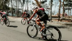 Triatlonininkai važiuoja dviračiais plentu saulėtą vasaros dieną sporto renginio metu Panevėžyje