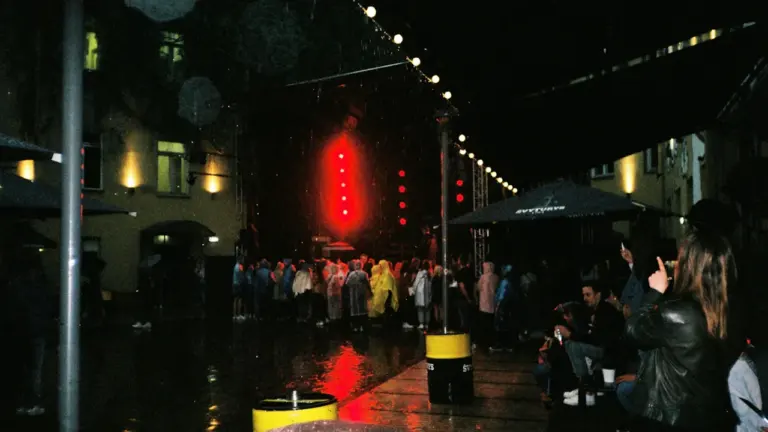Žmonių minia stebi koncertą naktį apšviestoje scenoje Vilniuje, Lietuvoje