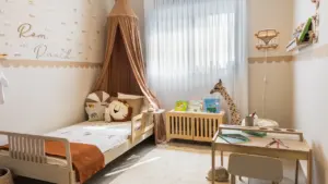Jaukus vaiko miegamasis su lova, stalu ir žaismingu interjero dizainu.